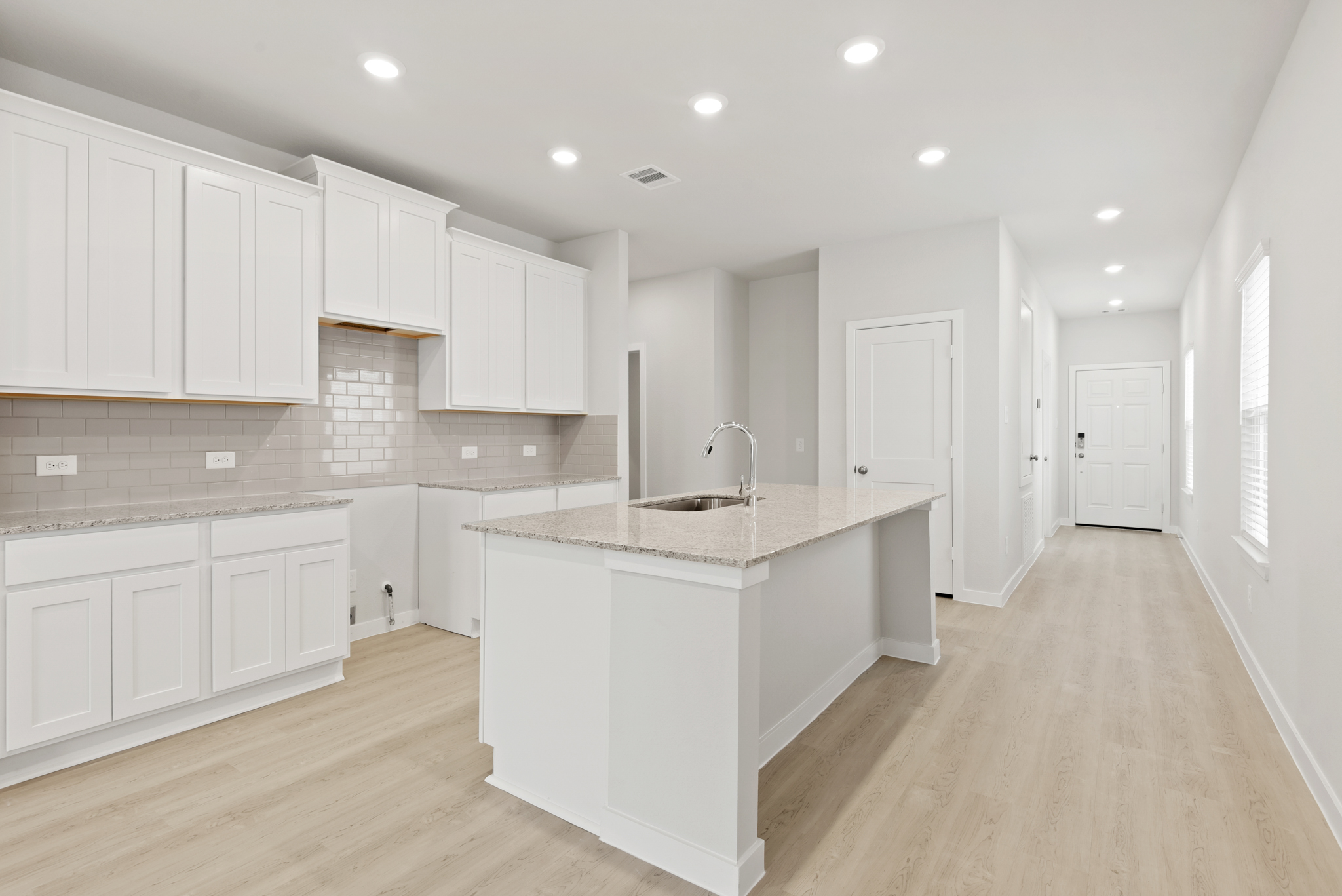 A kitchen with white cabinets.
