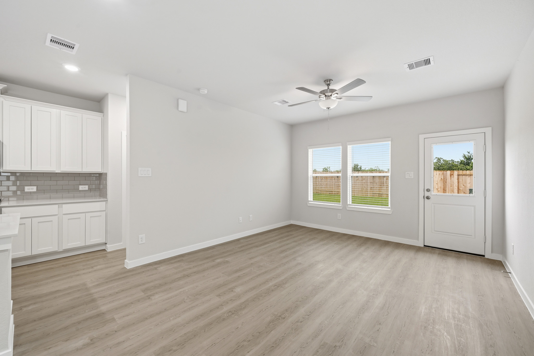 A room with white cabinets and a ceiling fan.