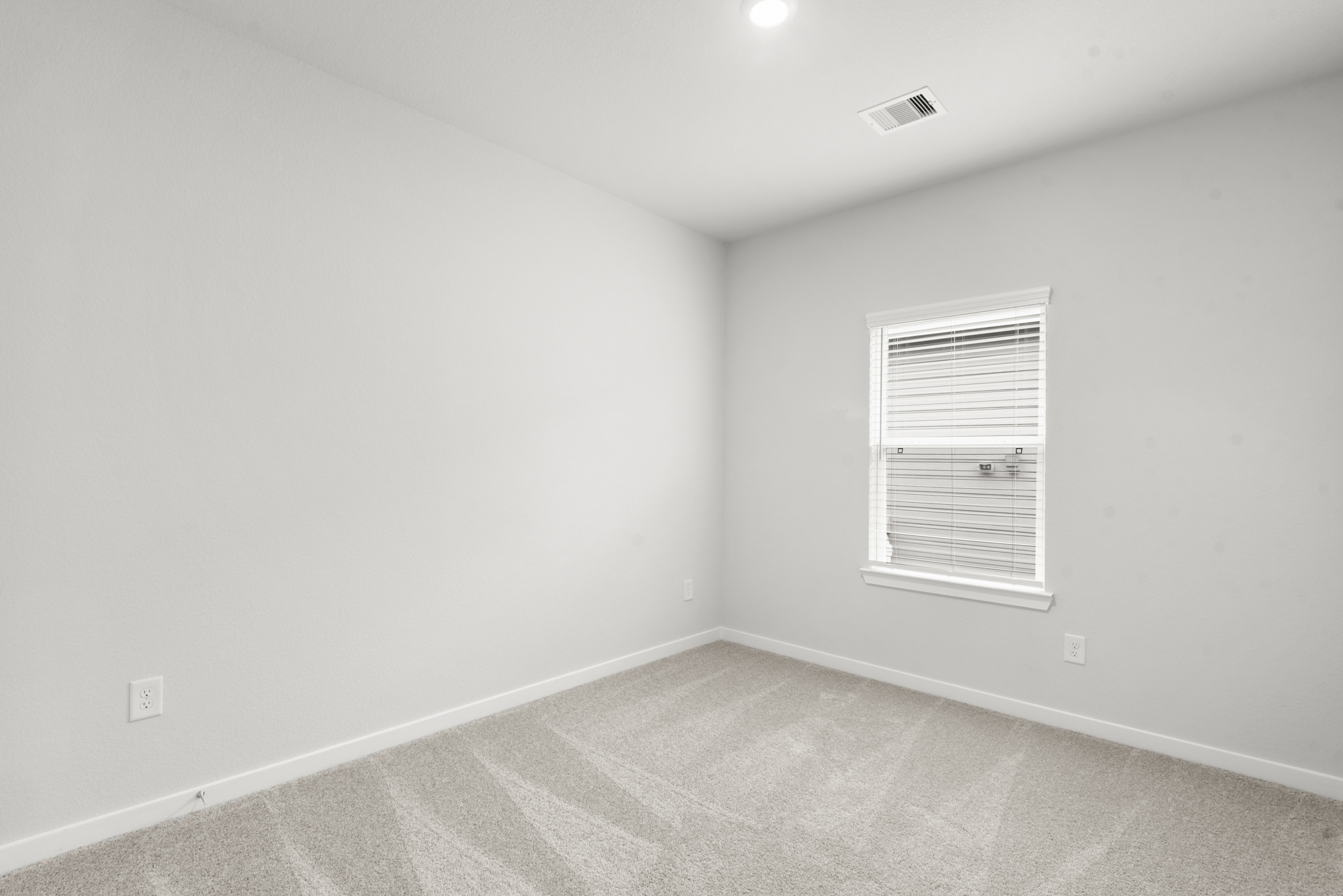 A room with a window and a carpet.