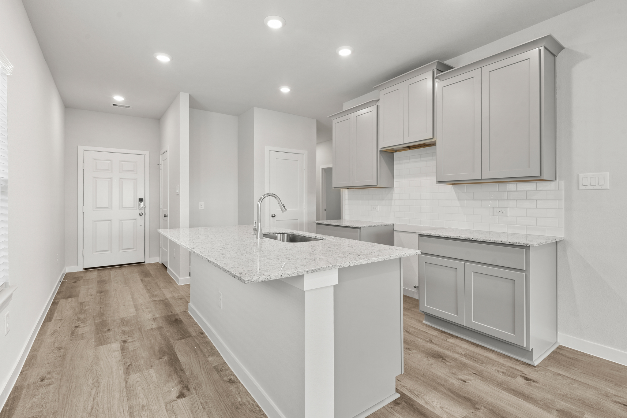 A kitchen with white cabinets.