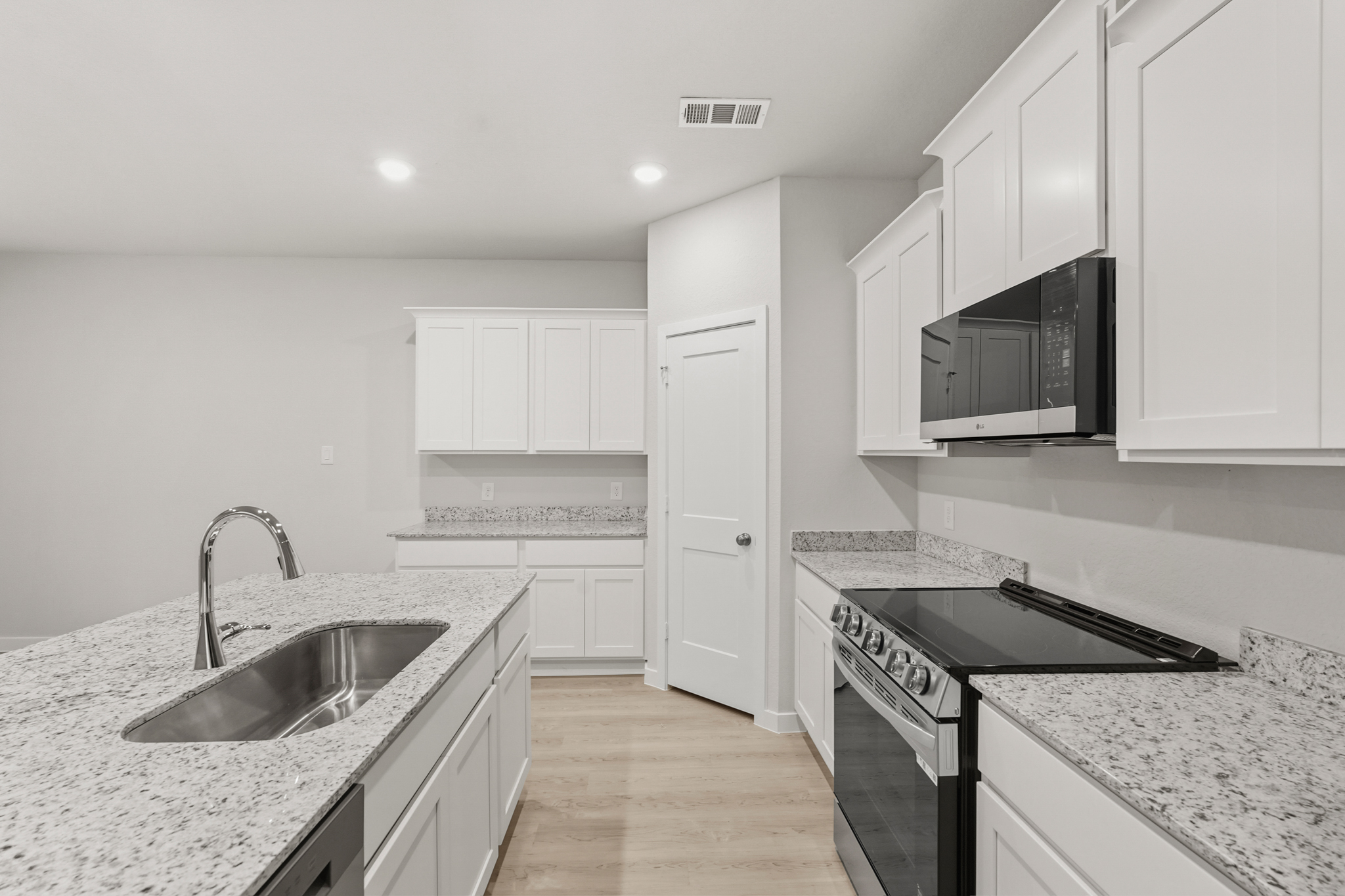 A kitchen with white cabinets.