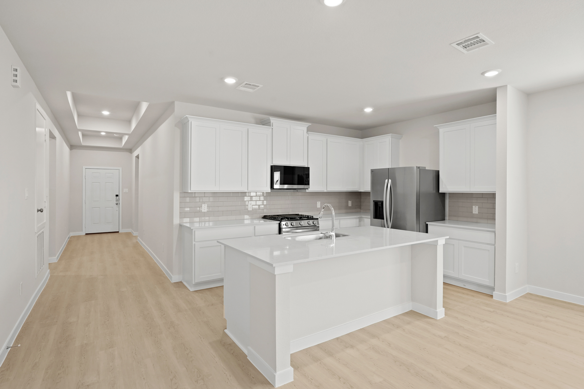 A kitchen with white cabinets.