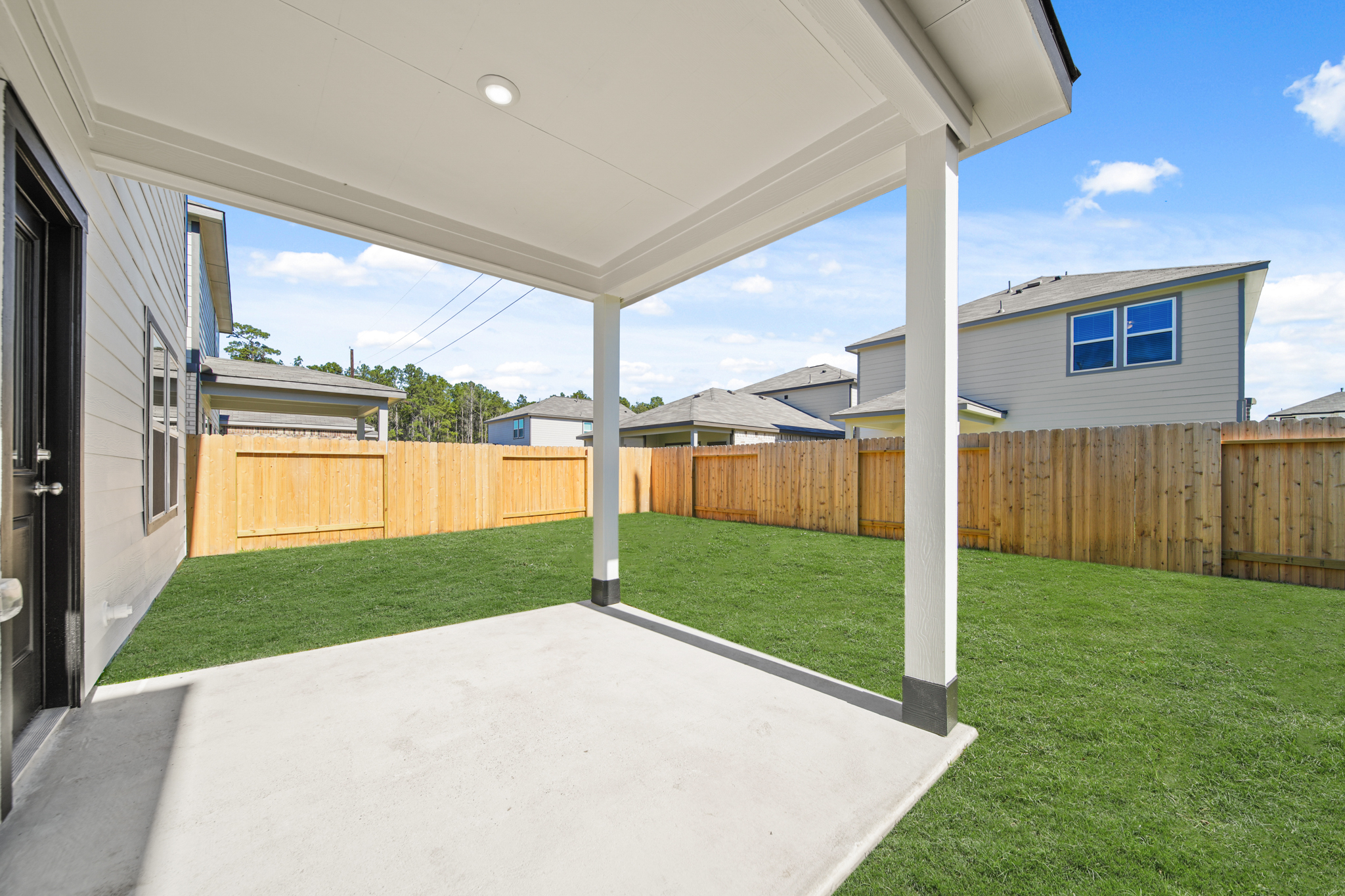 A backyard with a fence and a wood fence.