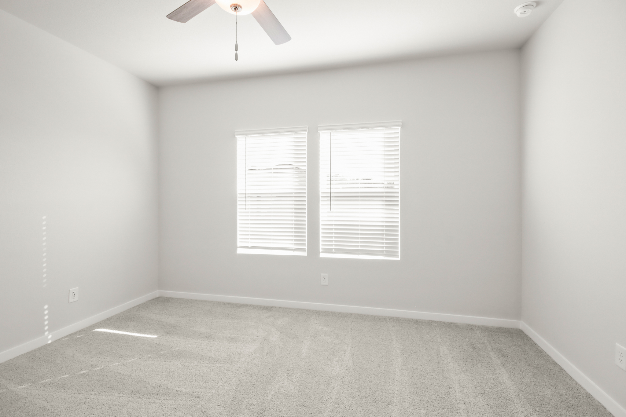 A room with a ceiling fan and a window.