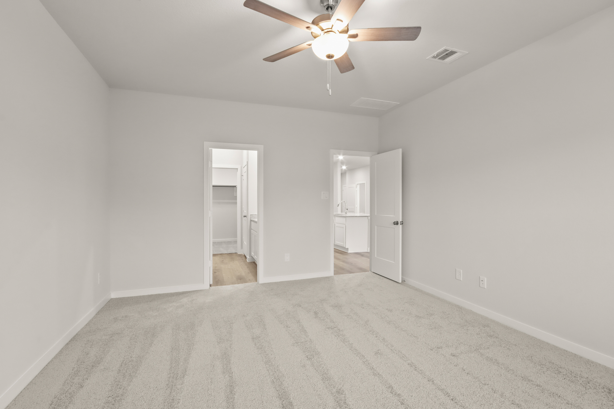 A room with a ceiling fan and a door.