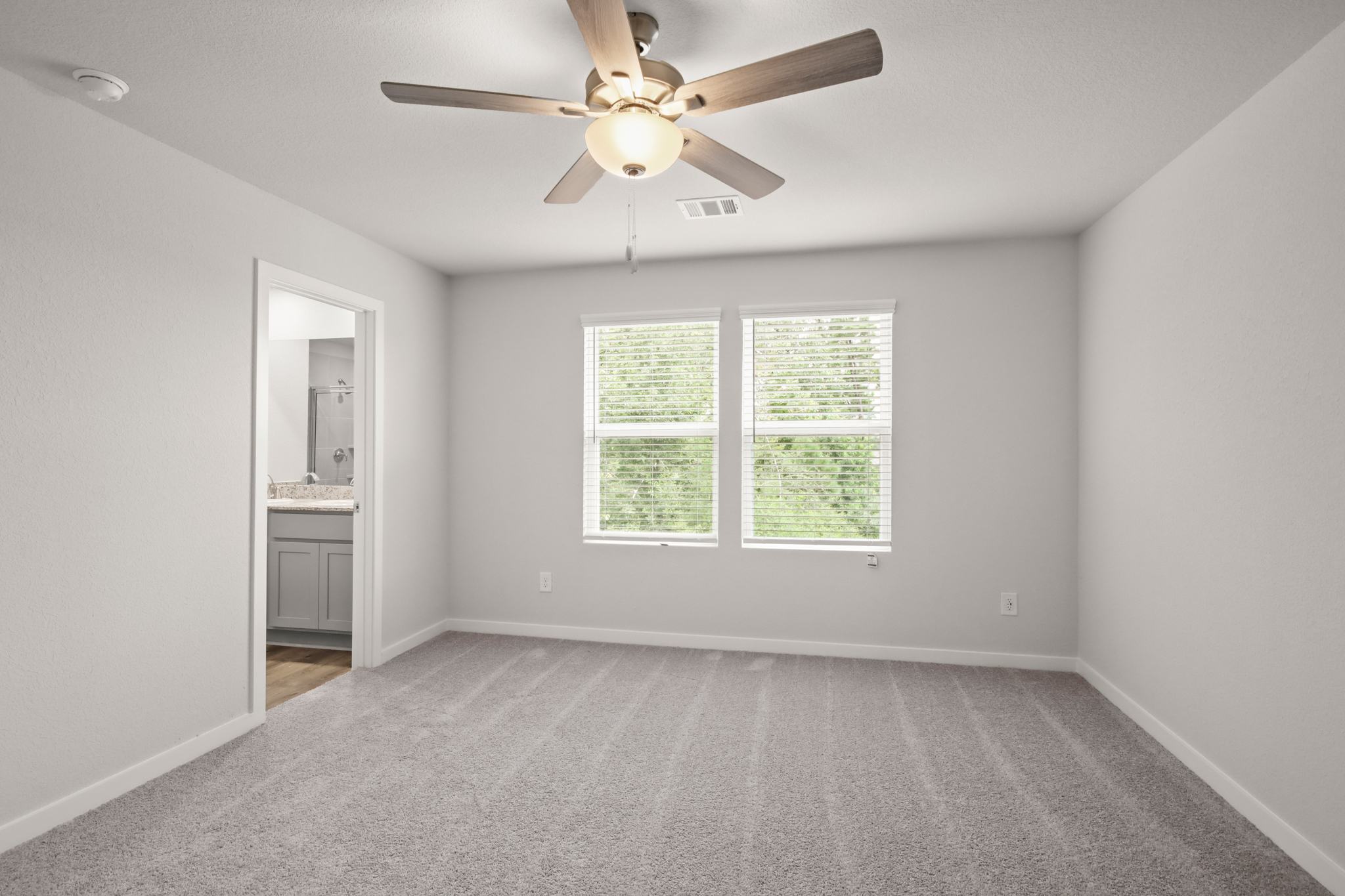 A room with a ceiling fan and a window.