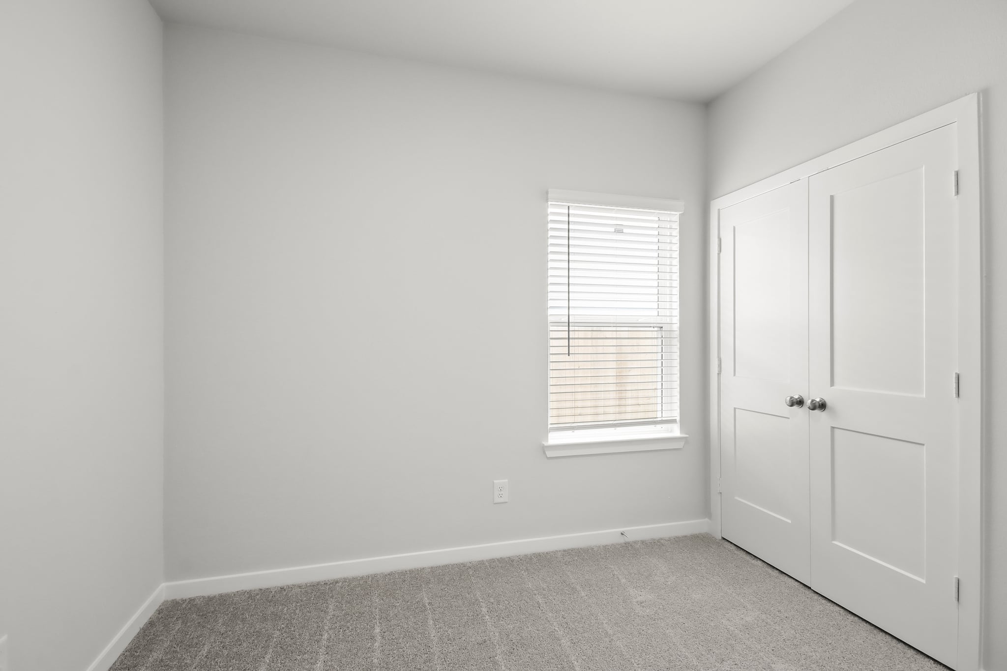 A room with white doors and a window.