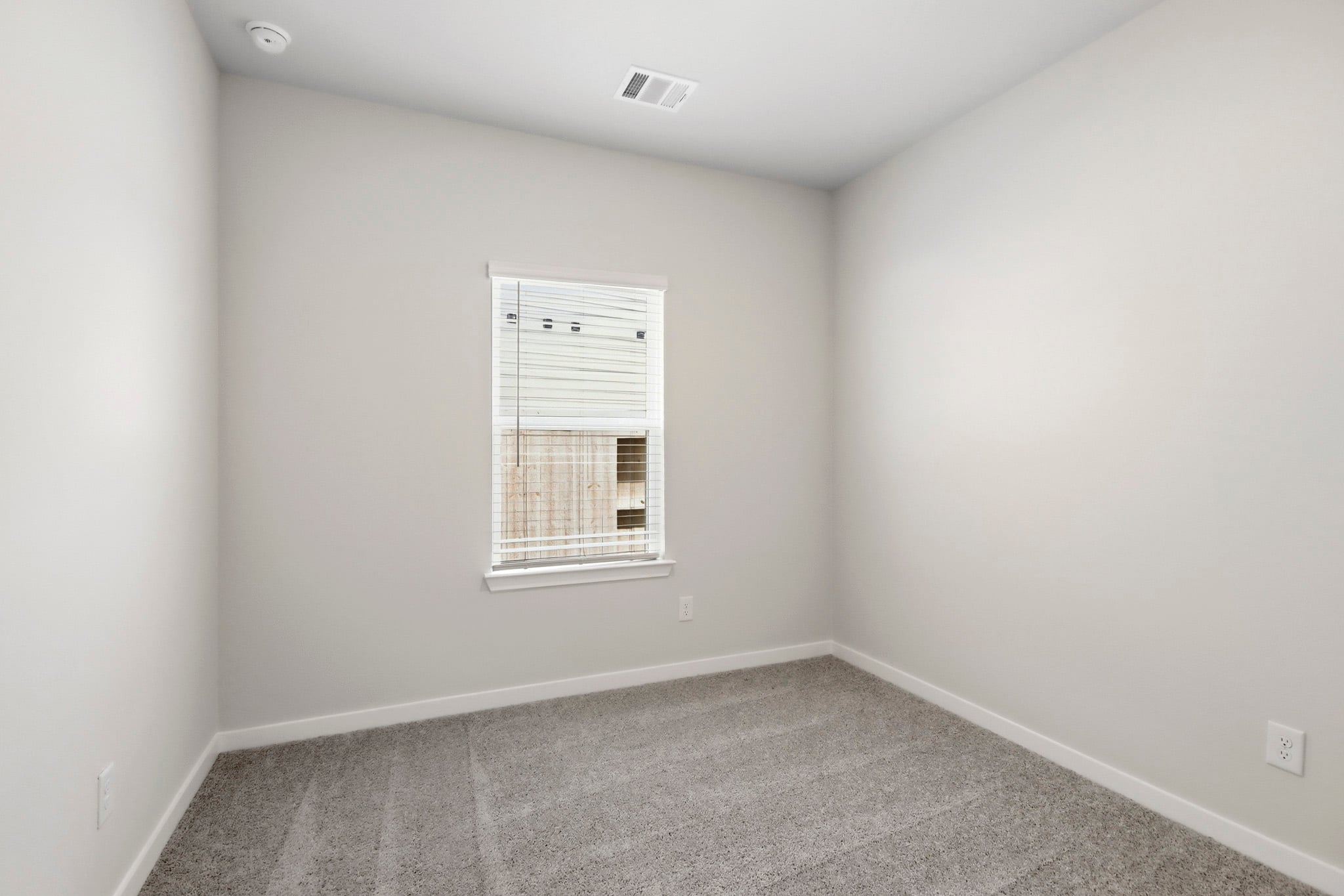 A room with a window and a vent.