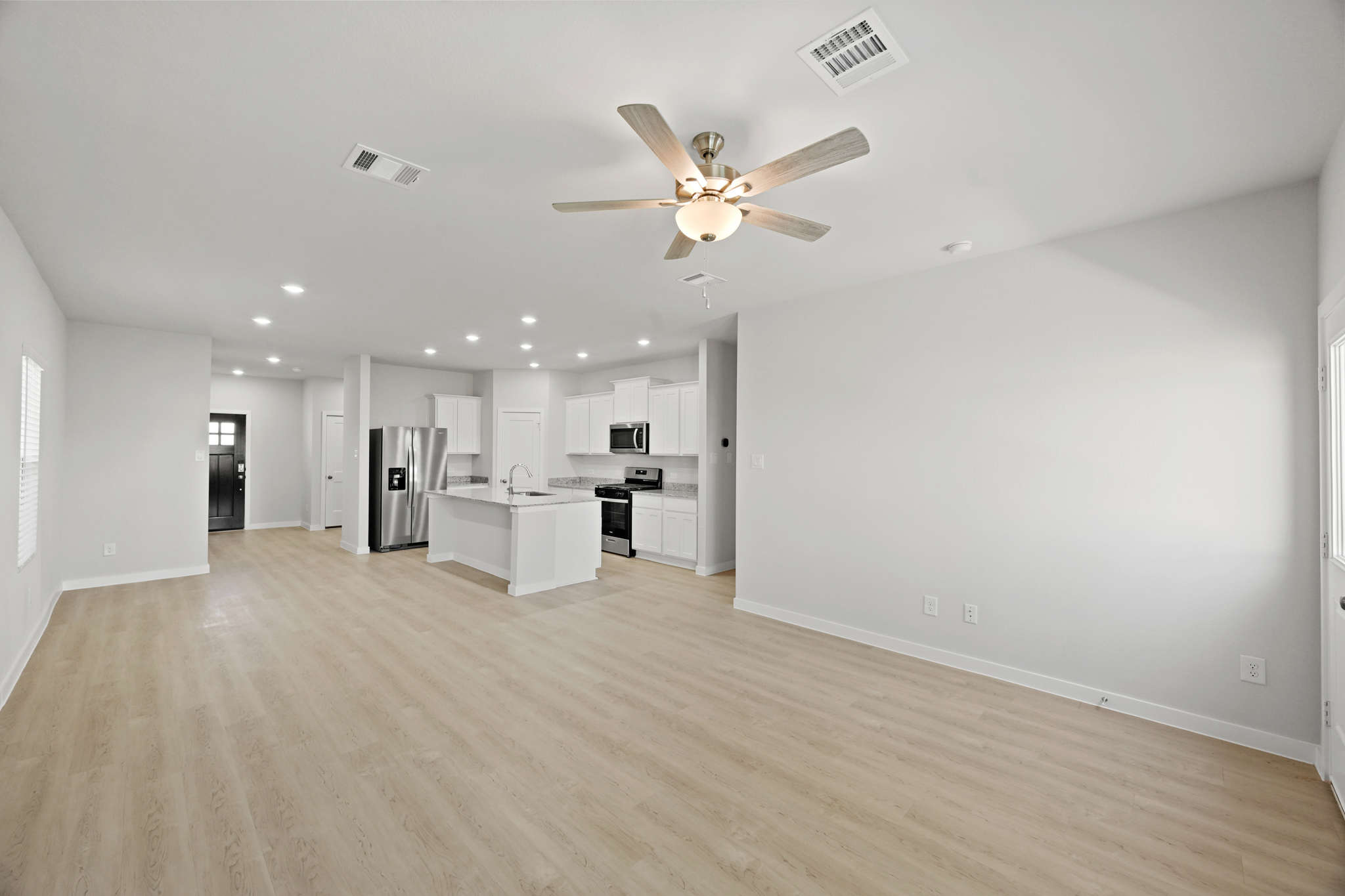 A large kitchen with a ceiling fan.