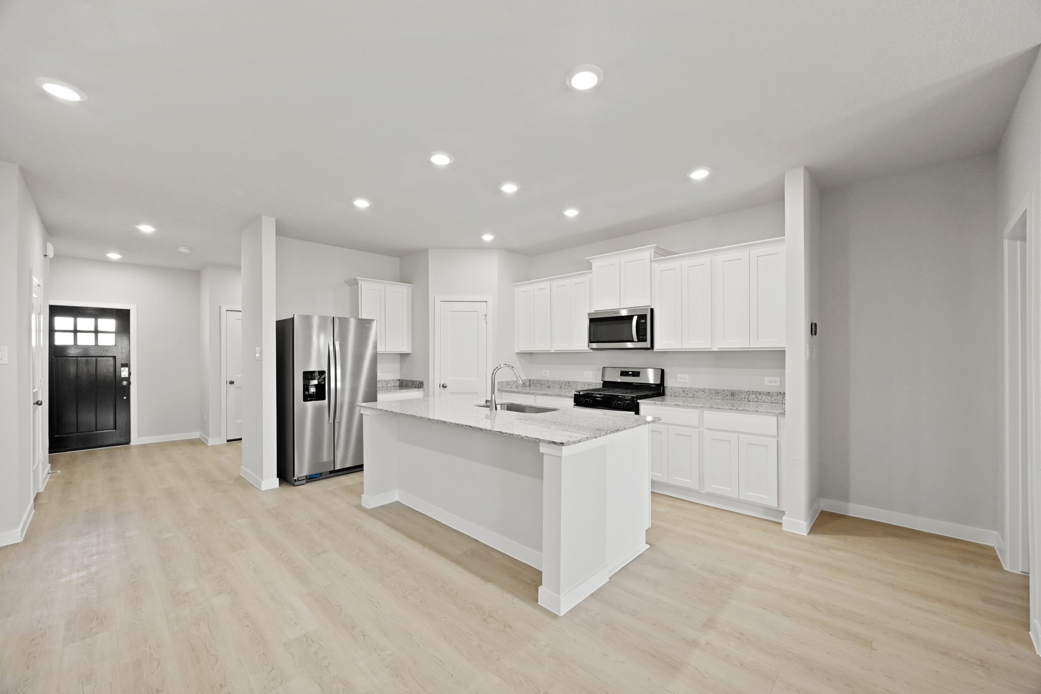 A kitchen with white cabinets.