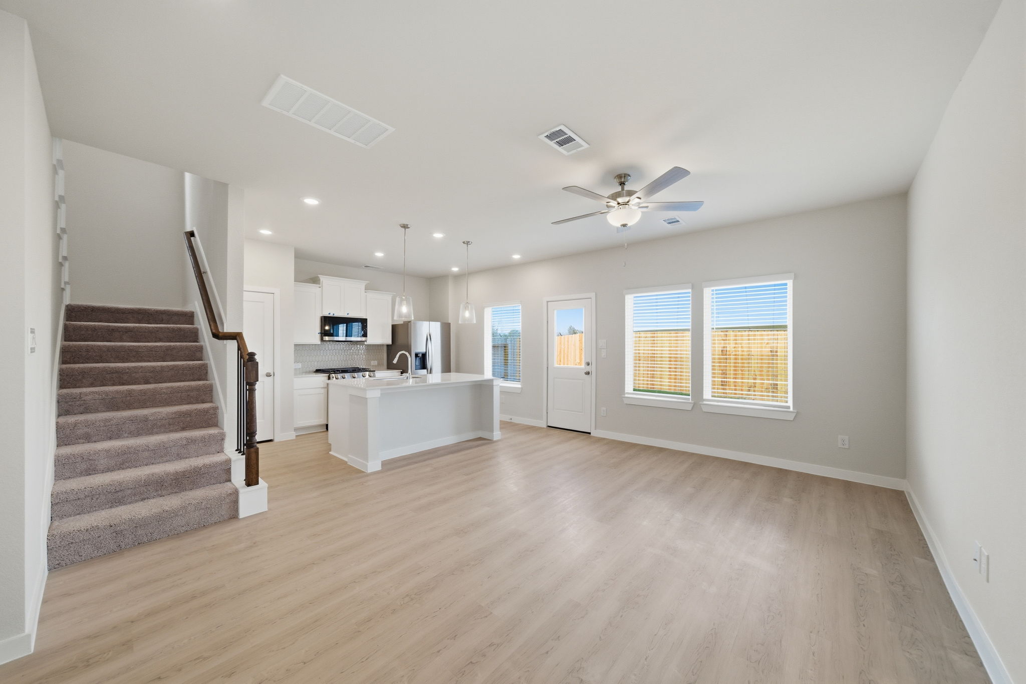 A large empty room with a wood floor and a white counter.