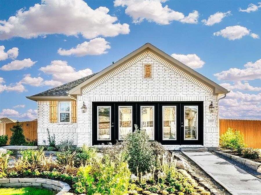 A house with a fence and bushes.