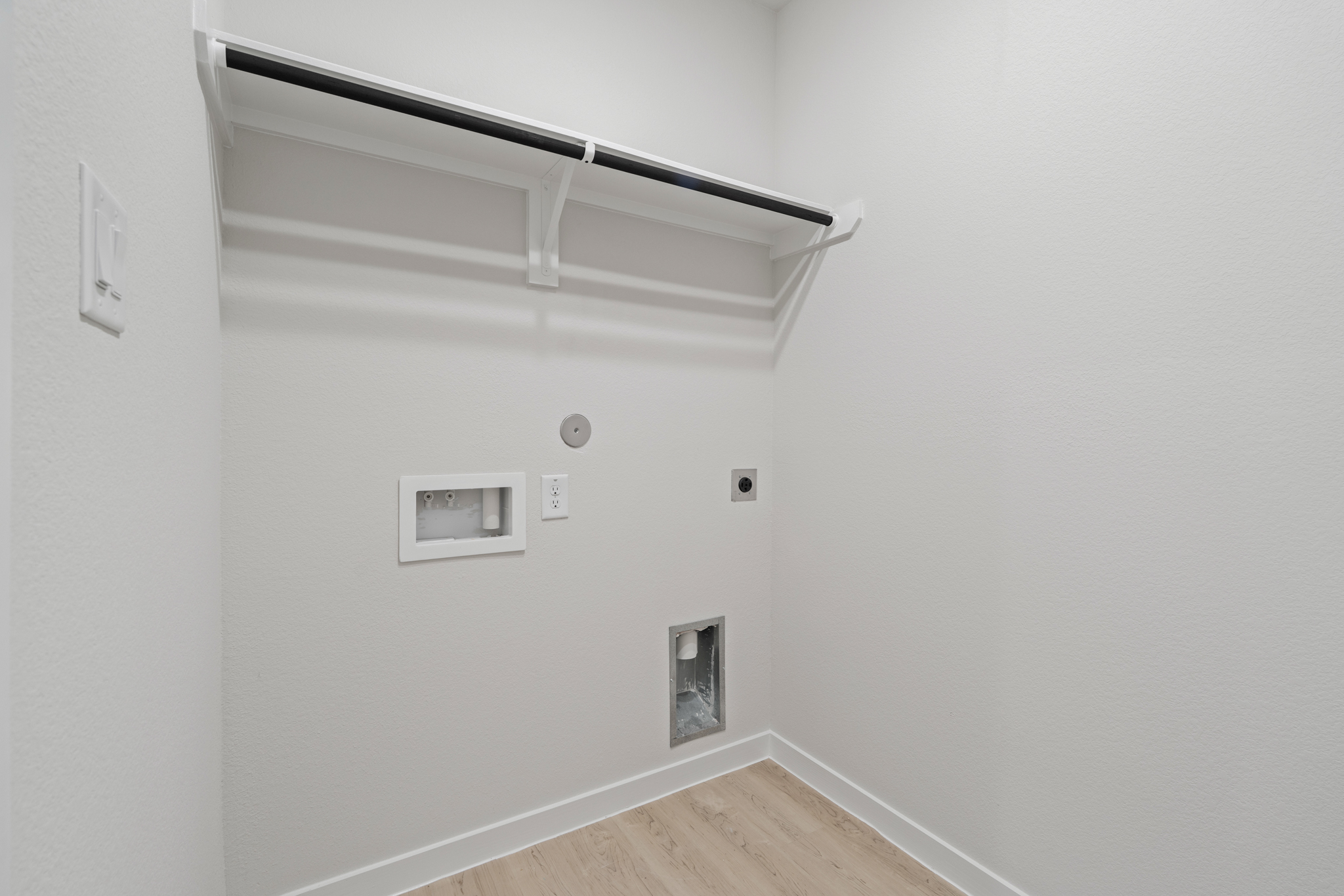 A white wall with a light fixture.