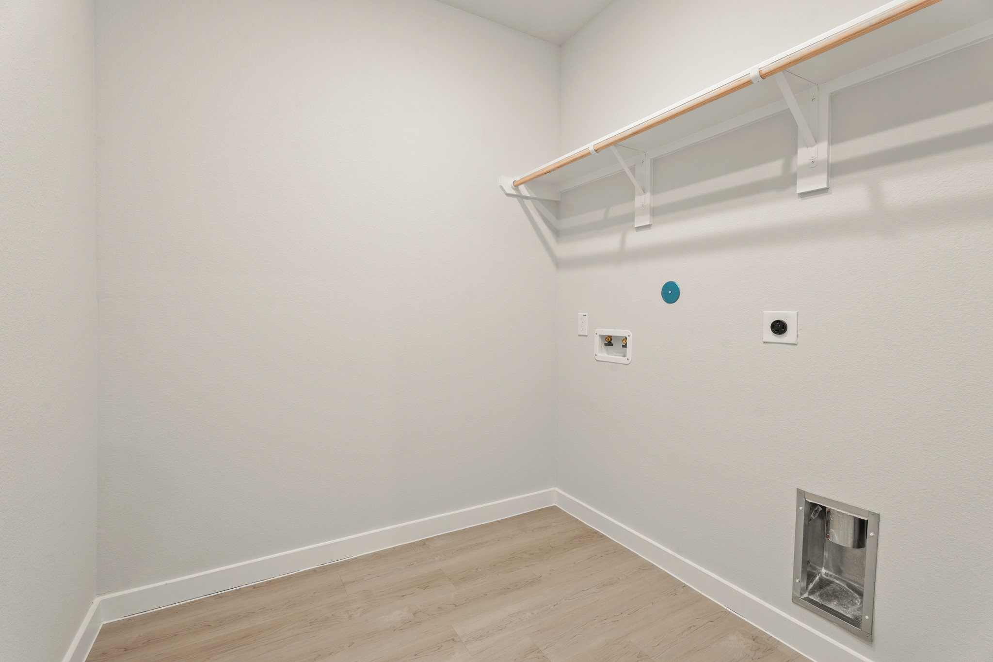 A white room with a wood floor and a white ceiling.