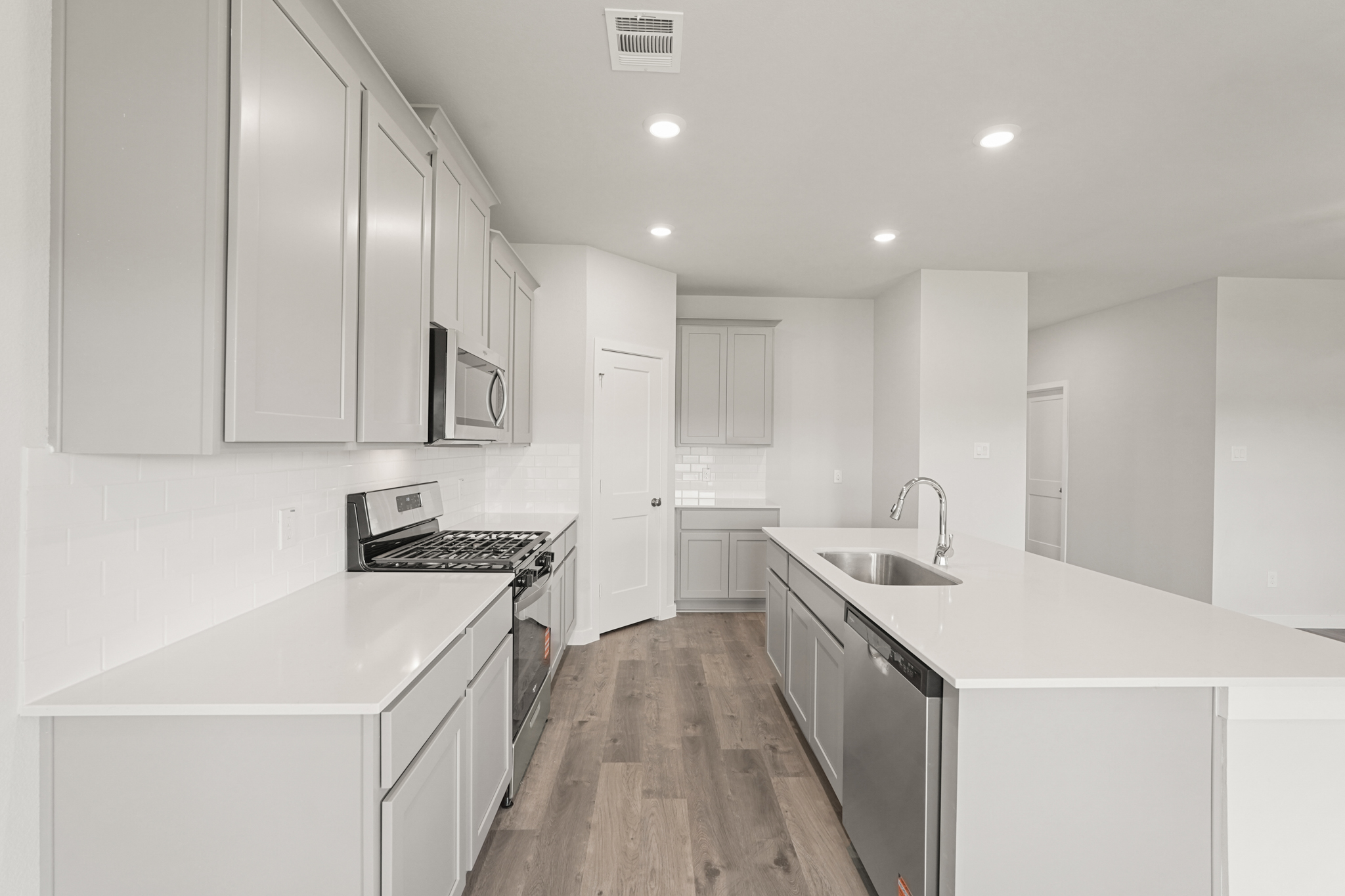 A kitchen with white cabinets.