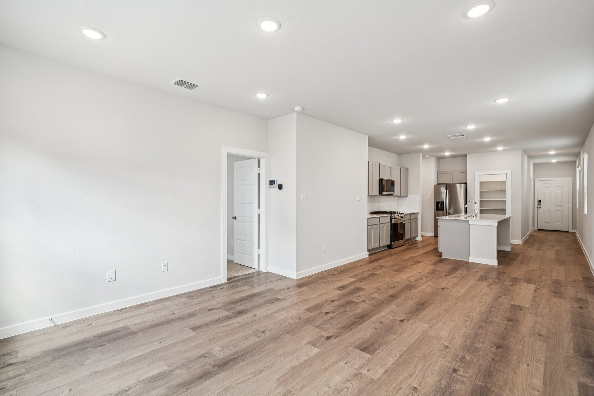 A room with white walls and wood floors.
