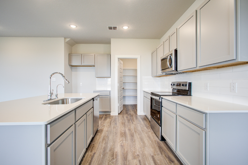 A kitchen with white cabinets.