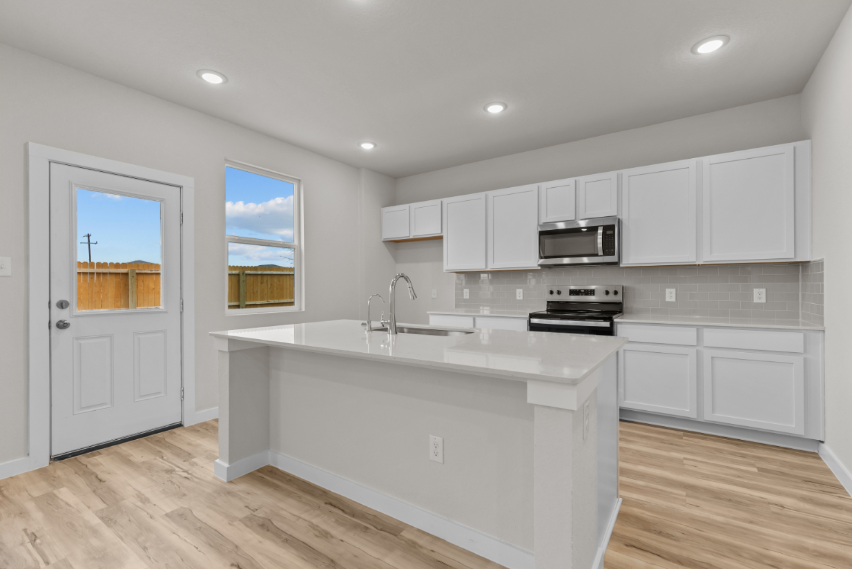 A kitchen with white cabinets.