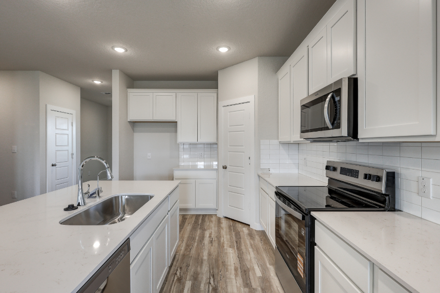 A kitchen with white cabinets.