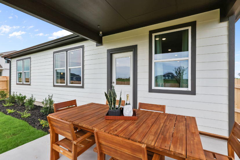 A table and chairs outside a house.