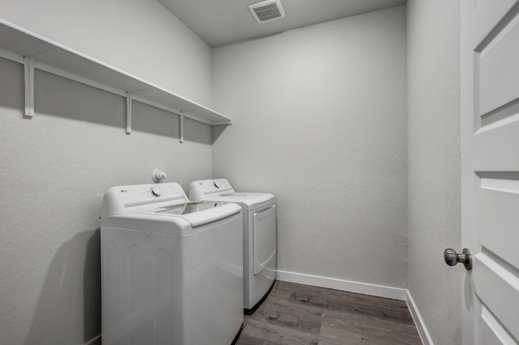 A room with a washing machine and a dryer.