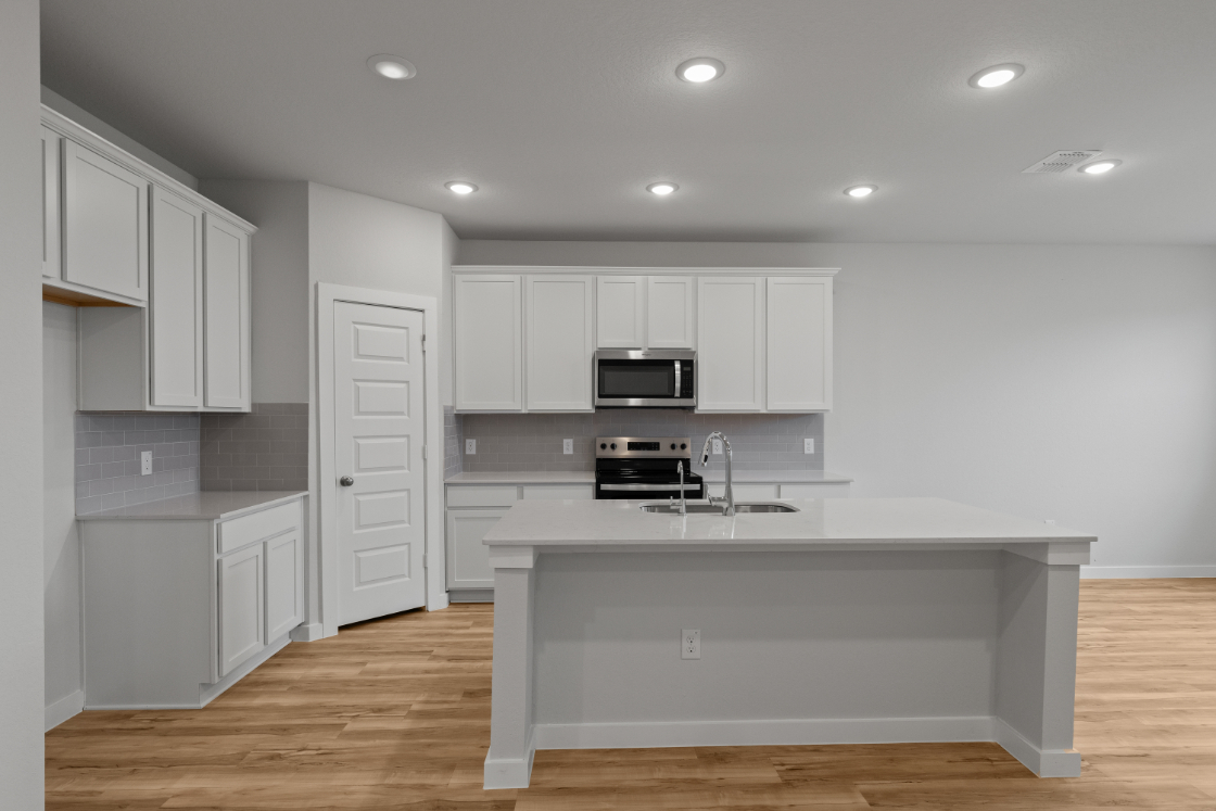 A kitchen with white cabinets.