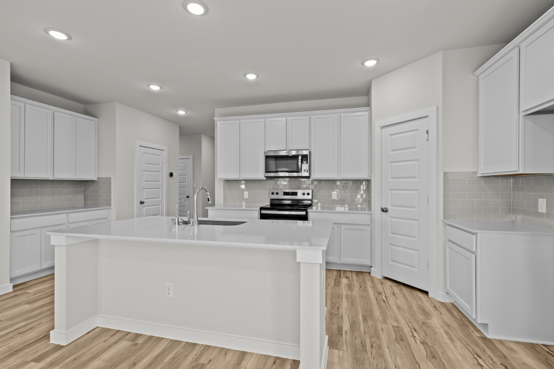 A kitchen with white cabinets.