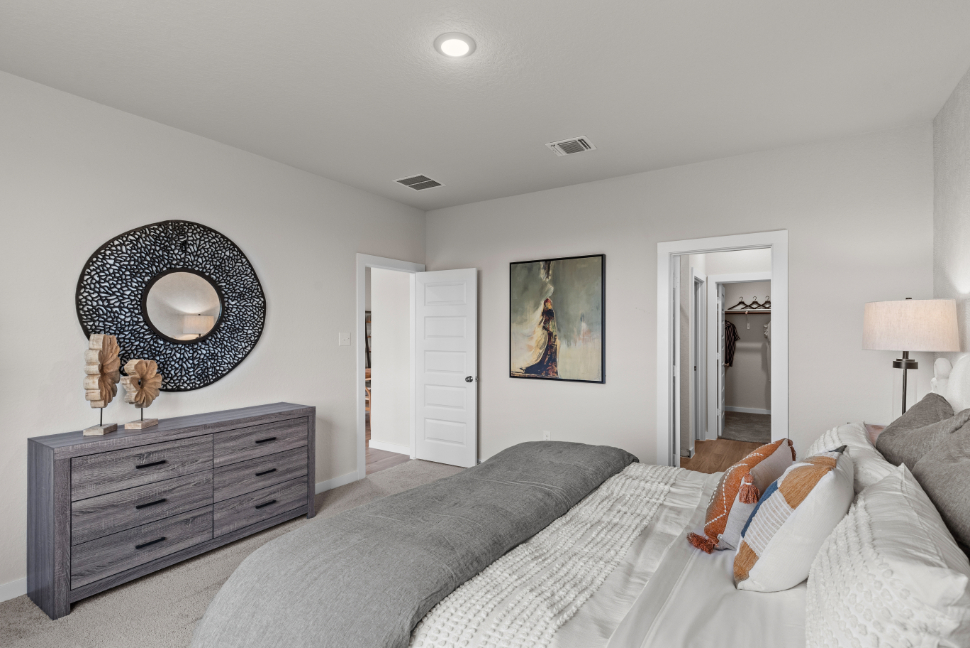 A bedroom with a bed and a mirror.