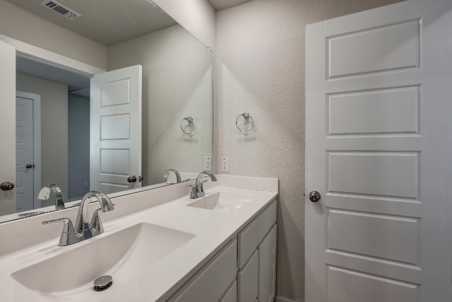 A bathroom with white cabinets.