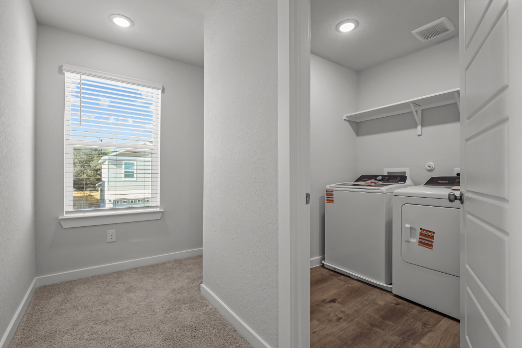 A room with a washing machine and a window.