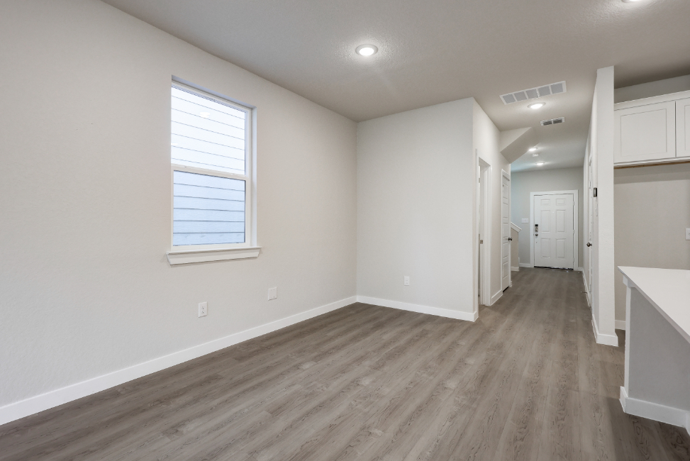 A room with white walls and wood floors.