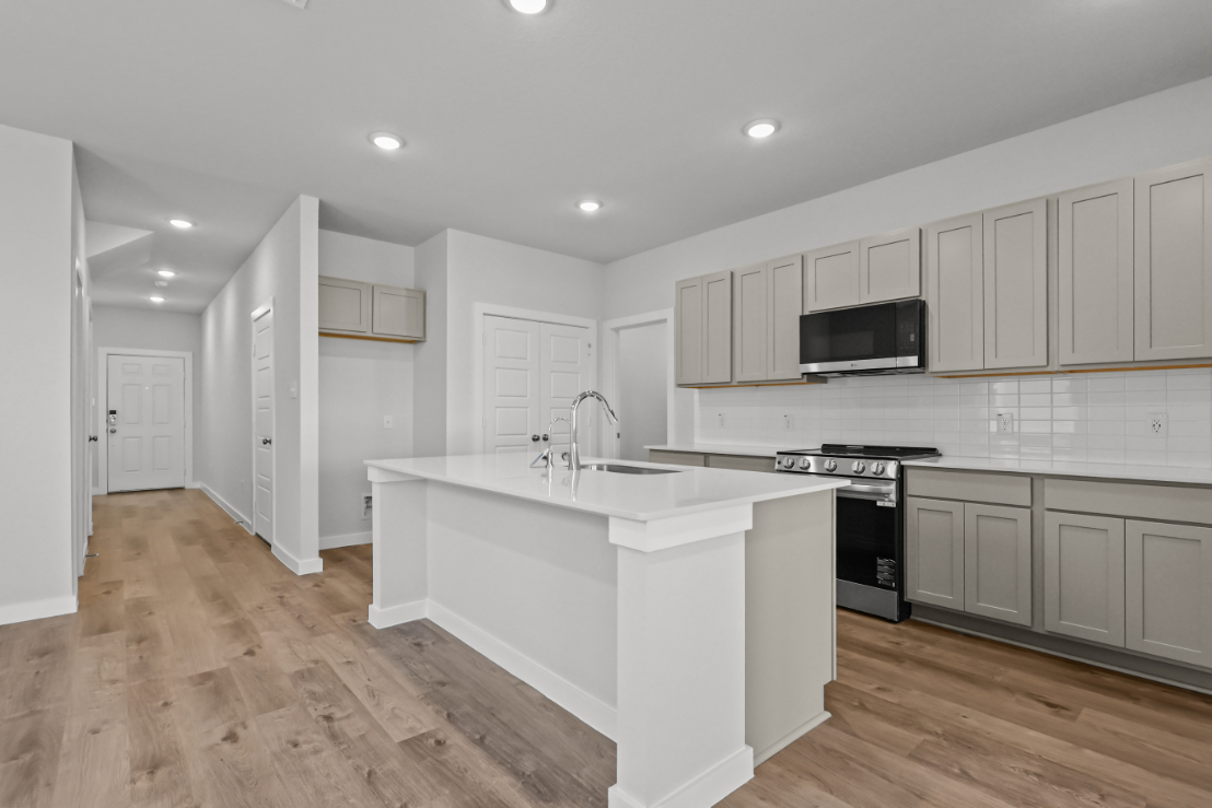 A kitchen with white cabinets.