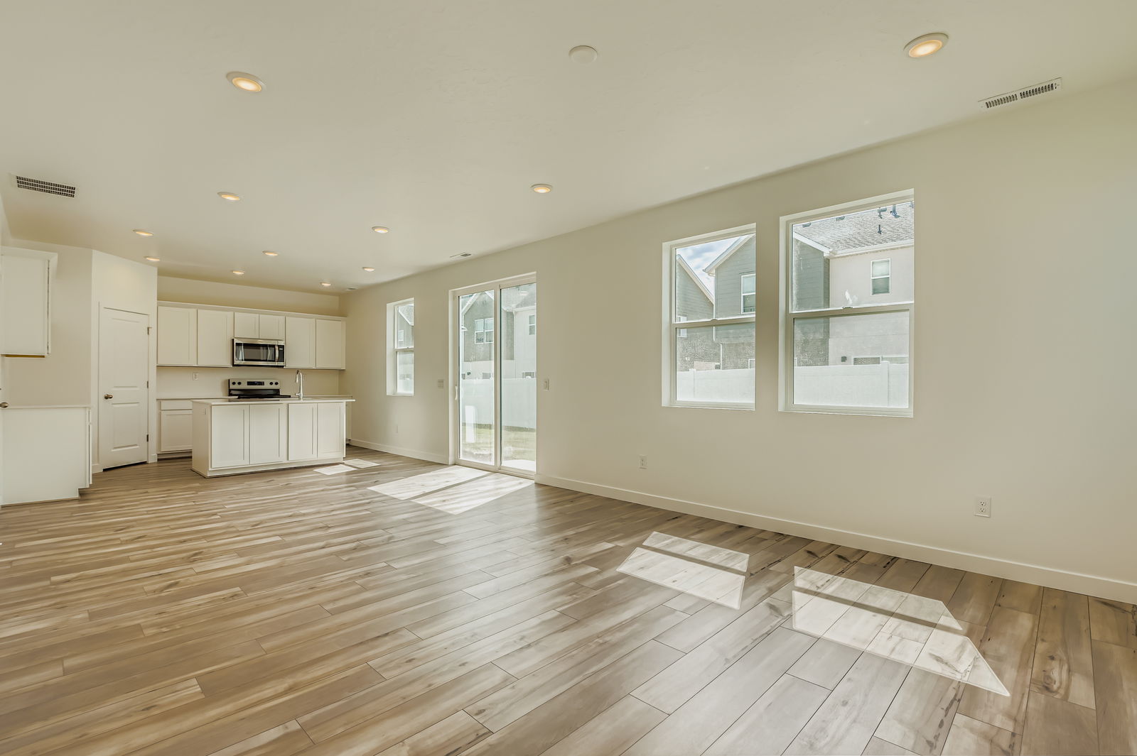 A large empty room with white cabinets.
