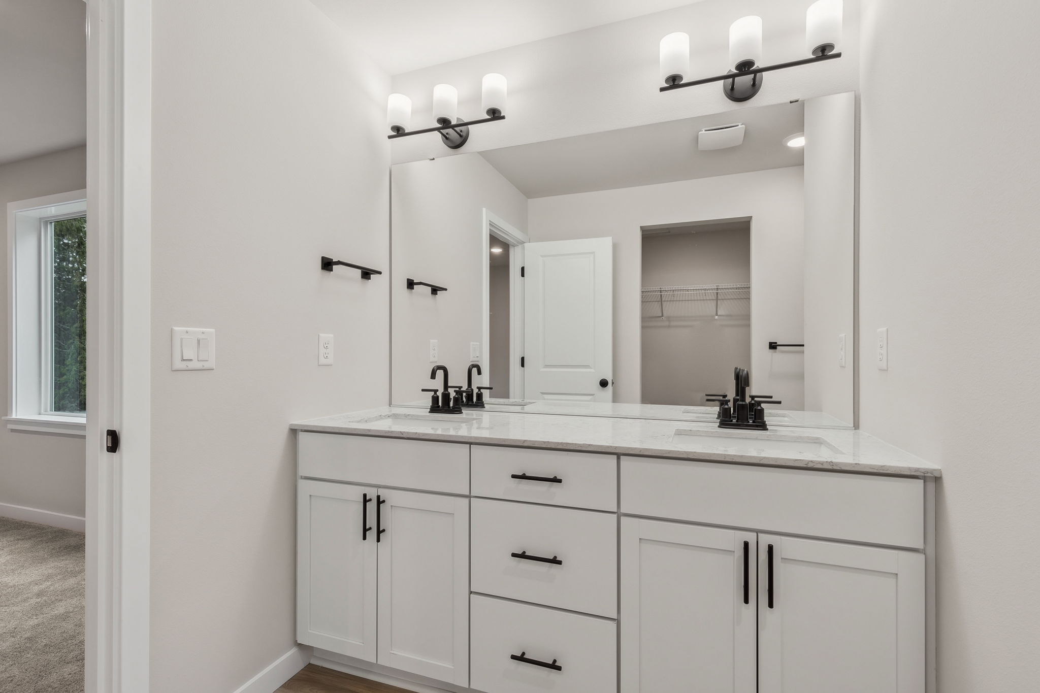 A bathroom with white cabinets.