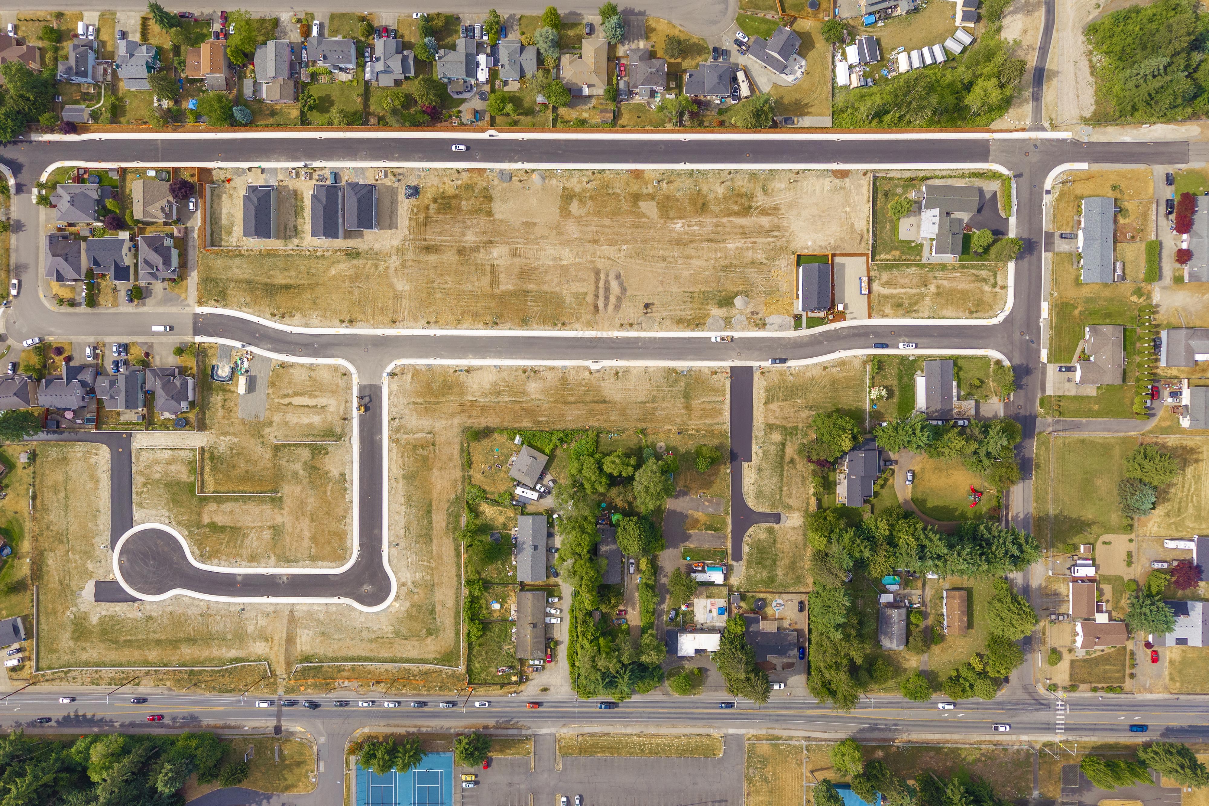 A large building with a road and trees in front of it.