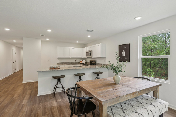 A kitchen with a table and chairs.