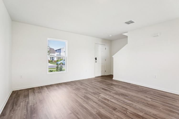 A room with a wood floor and a painting on the wall.