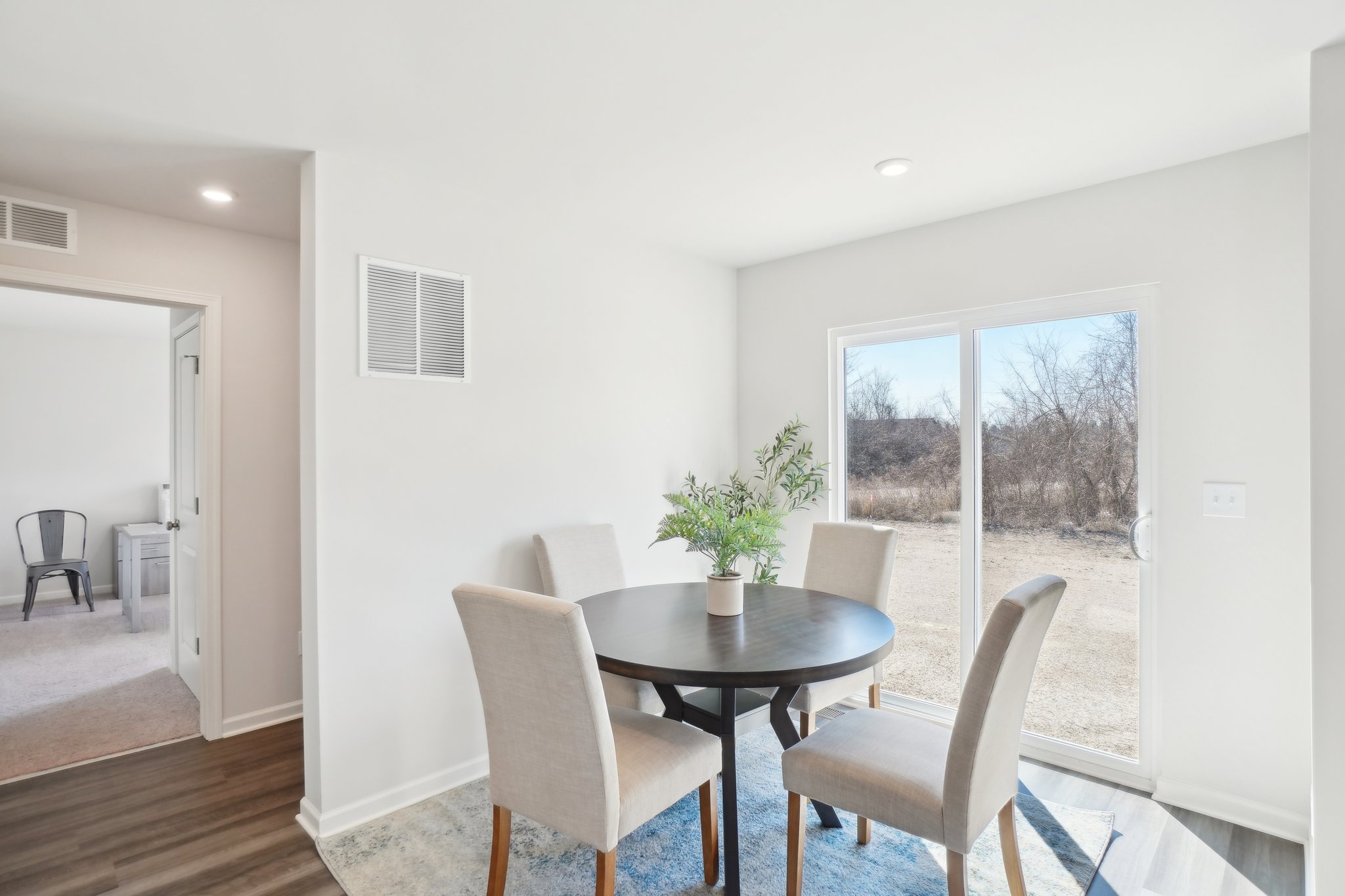 A dining room with a table and chairs.