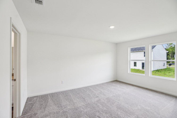 A room with a carpet and windows.