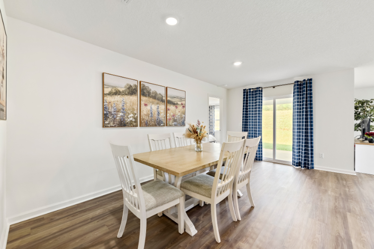 A dining room with a table and chairs.