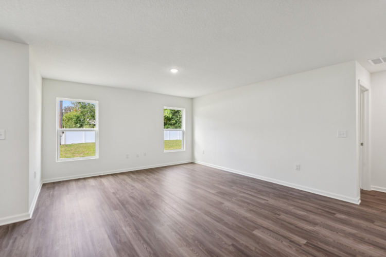 A room with a wood floor and windows.