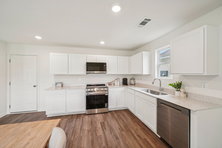 A kitchen with white cabinets.