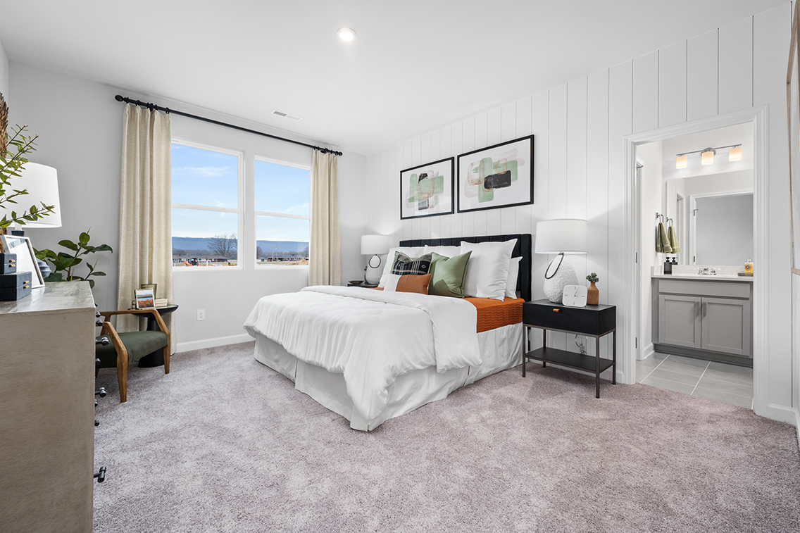 A bedroom with a large window.