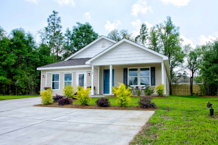 A house with a yard and trees with Little White House in the background.