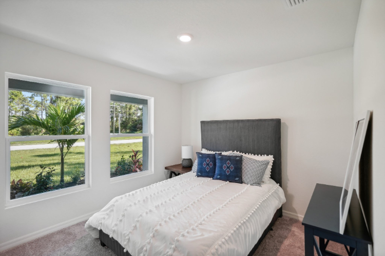 A bedroom with a large window.