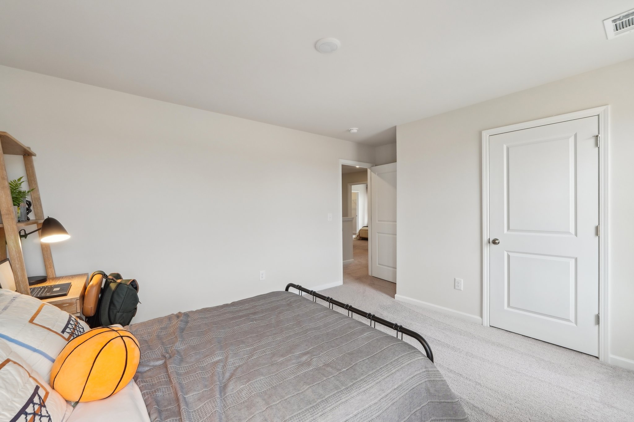 A bedroom with a bed and a lamp.