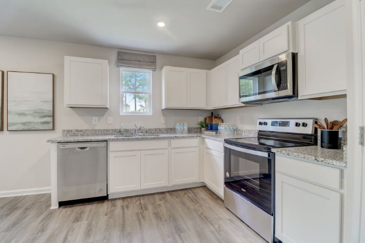 A kitchen with white cabinets.